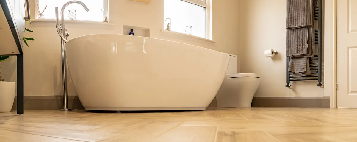Loft bathroom with a freestanding bath and herringbone floor