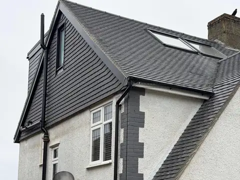 Hip-to-gable loft conversion with a tile-hung gable on a white rendered house
