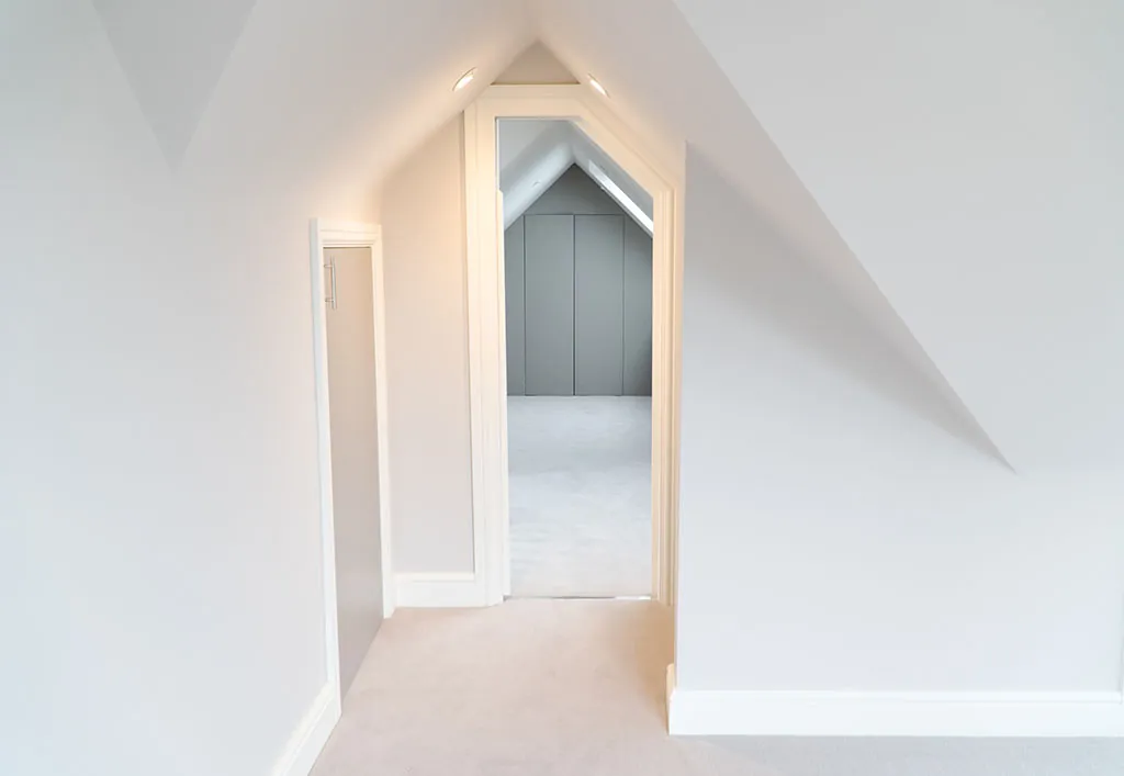 Loft landing with a doorway shaped to the roof line